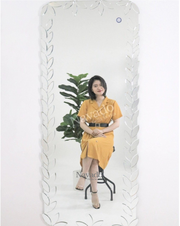 Full-length wall-mounted mirror with small pieces of art