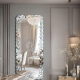 Full-length wall-mounted mirror with small pieces of art